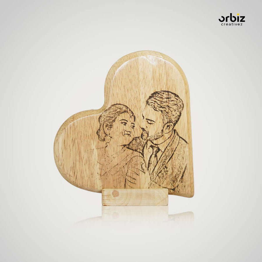 A couple's portrait engraved on a heart-shaped wooden frame
